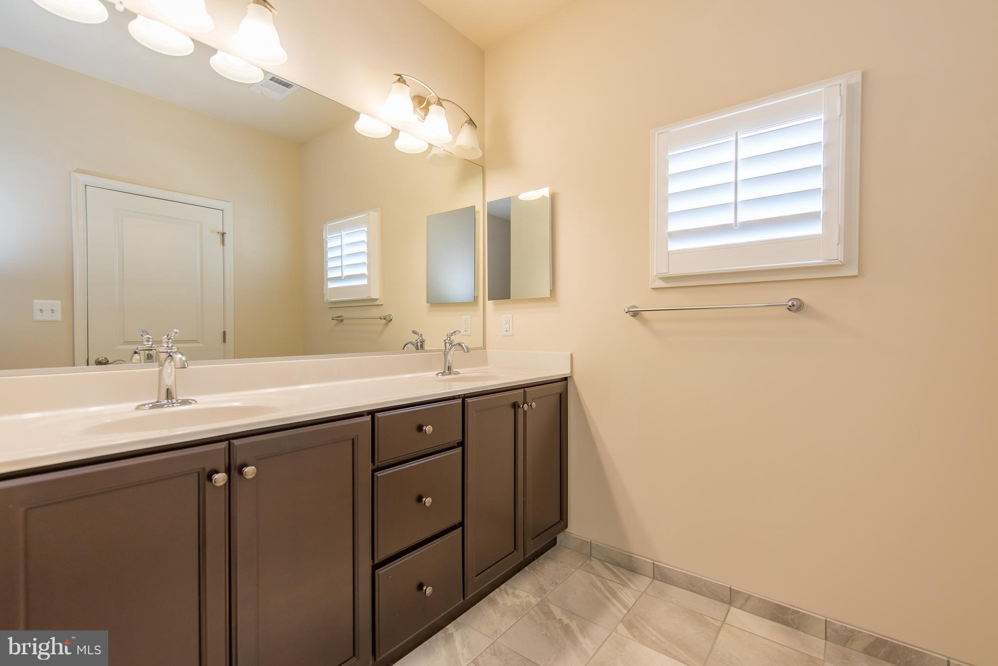 1163 Holden Road Frederick, MD 21701 - Photo 17 of 30 a bathroom with a double vanity sink a mirror and a bathtub