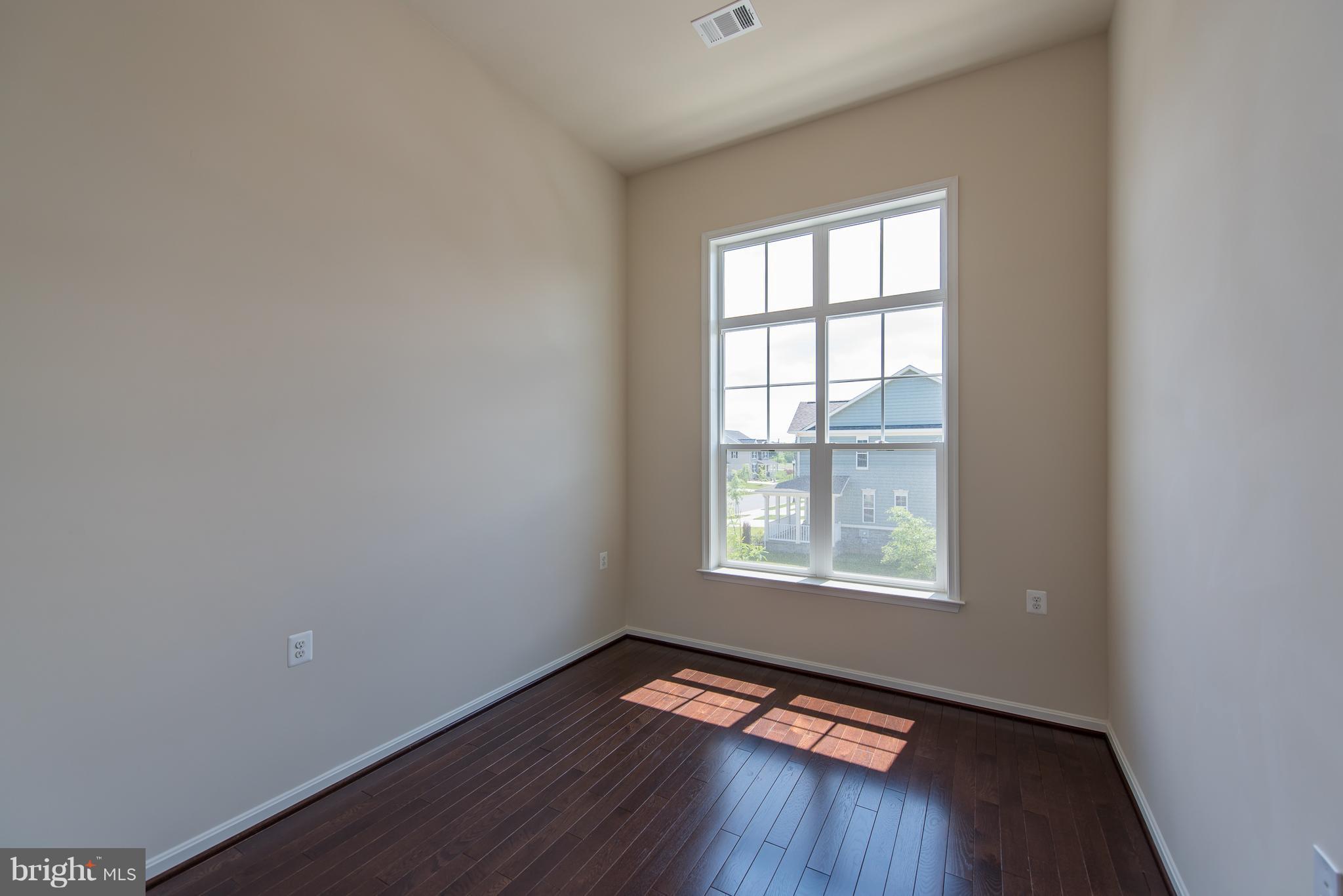 1163 Holden Road Frederick, MD 21701 - Photo 20 of 30 an empty room with wooden floor and windows