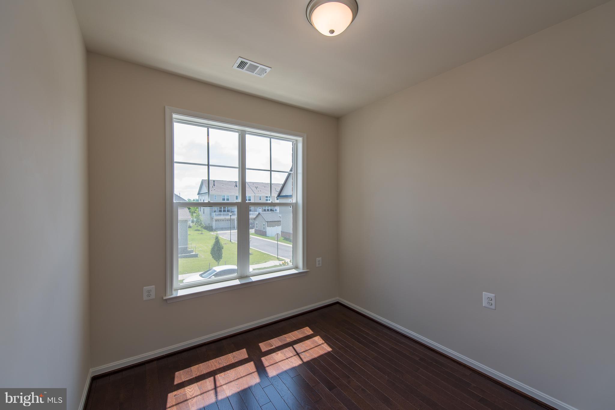 1163 Holden Road Frederick, MD 21701 - Photo 21 of 30 an empty room with wooden floor and windows