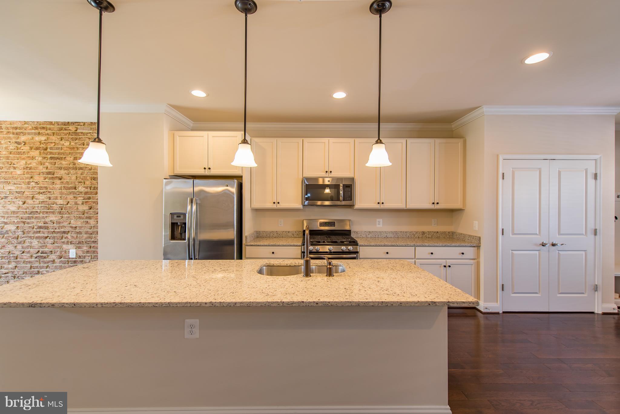 1163 Holden Road Frederick, MD 21701 - Photo 4 of 30 a kitchen with kitchen island a sink stainless steel appliances and a counter top