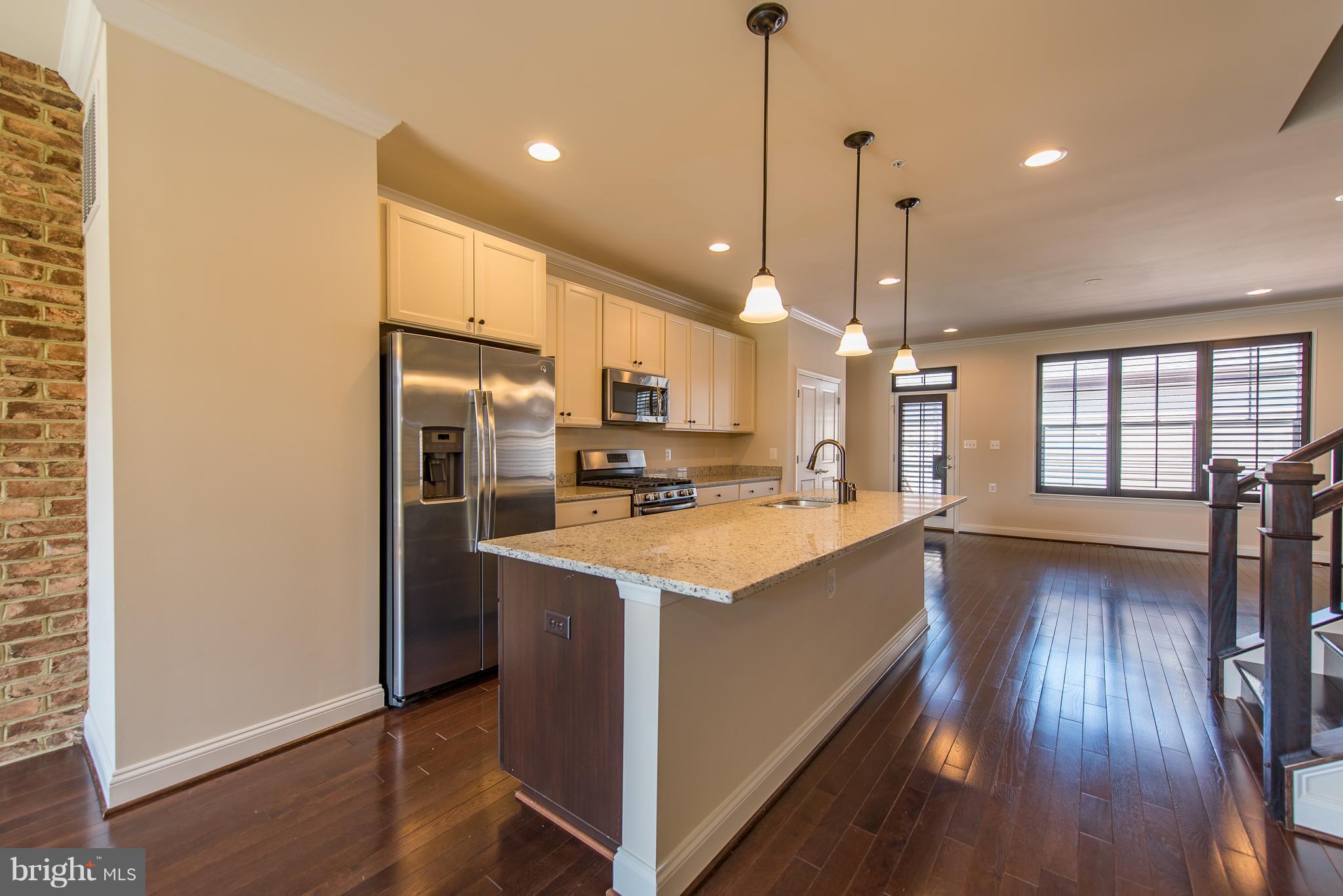 1163 Holden Road Frederick, MD 21701 - Photo 5 of 30 a kitchen with stainless steel appliances granite countertop a refrigerator a sink dishwasher a stove and white countertops with wooden floor