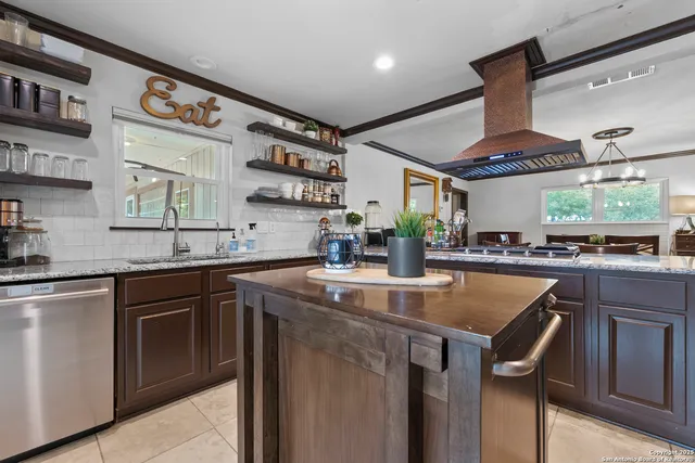 a kitchen with stainless steel appliances granite countertop a sink and a stove