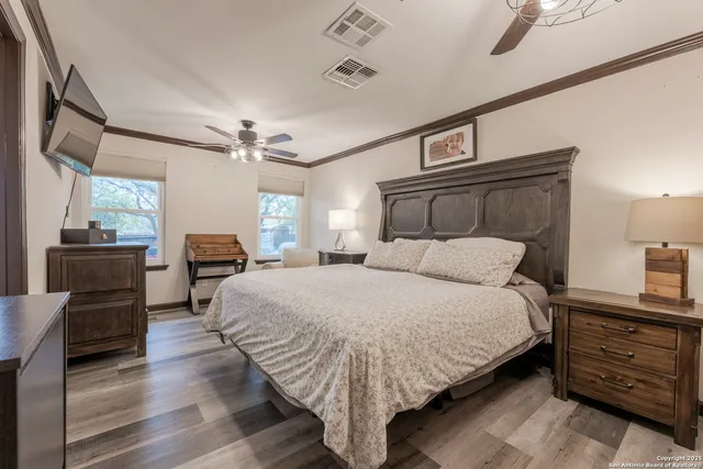 a large bedroom with a bed and wooden floor