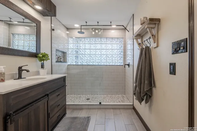 a bathroom with a sink a mirror and shower