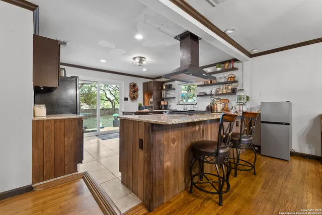 a kitchen with stainless steel appliances granite countertop a stove top oven a sink and a refrigerator