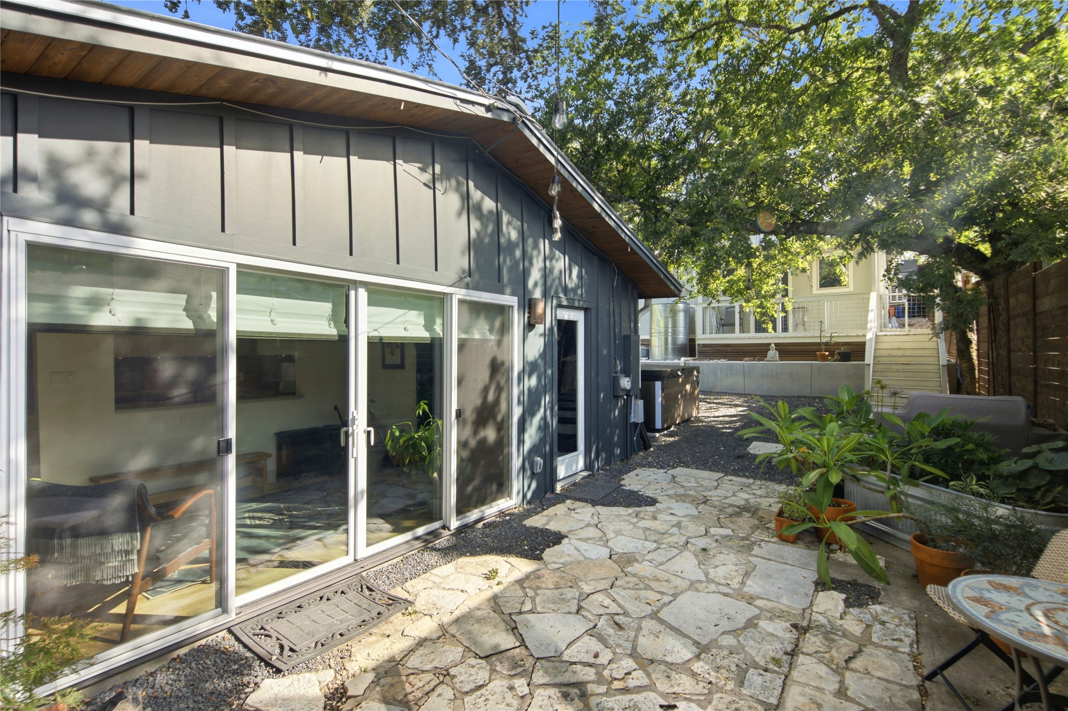 5600 Ledesma Road Austin, TX 78721 - Photo 17 of 36 A stone patio extends from the back of the home beneath a canopy of mature trees.