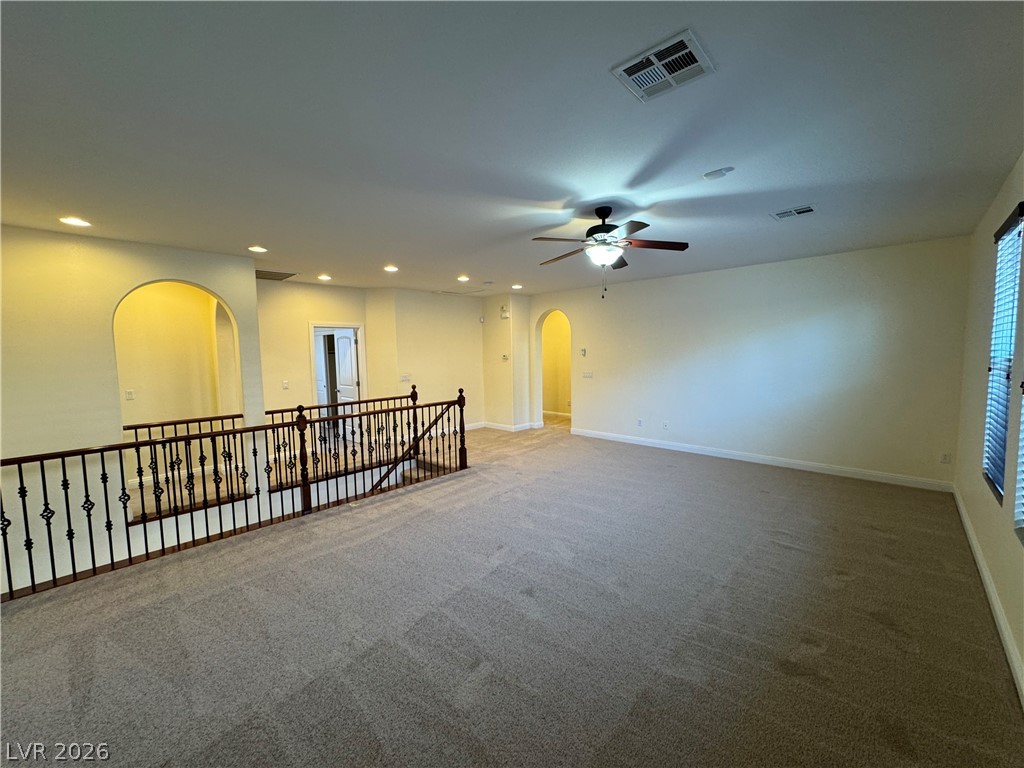 1333 Jamesbury Road Las Vegas, NV 89135 - Photo 26 of 43 A spacious upstairs loft provides flexible living space, complemented by architectural arches and recessed lighting.