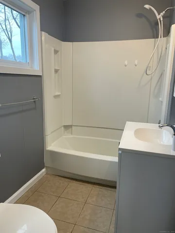 a bathroom with a sink a bathtub and window