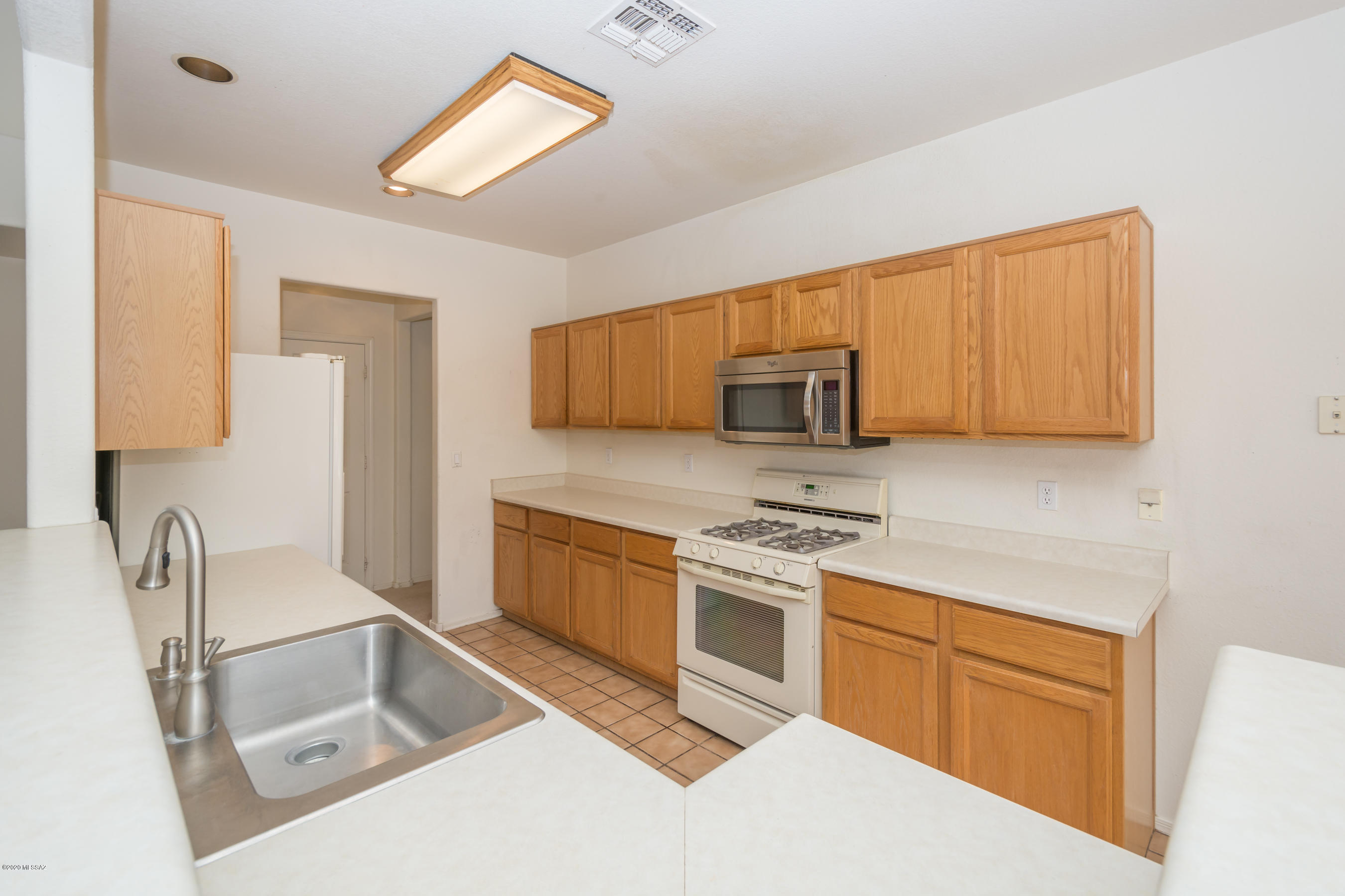 11341 Silver Pheasant Loop Oro Valley, AZ 85737 - Photo 4 of 41 a kitchen with stainless steel appliances granite countertop a sink stove and microwave