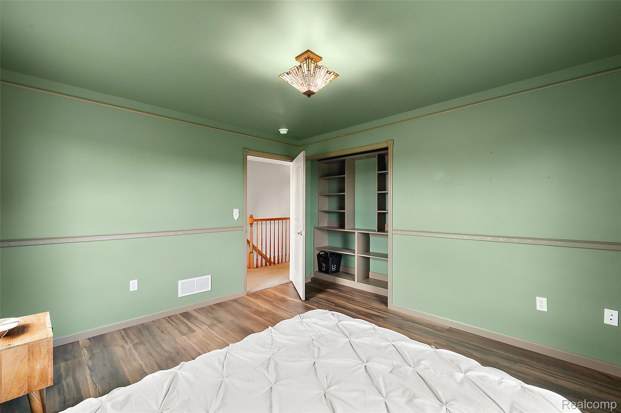 5035 Hidden Ridge Road Metamora, MI 48455 - Photo 39 of 65 Room featuring wood-finish flooring, light green walls with chair rail molding, and a built-in closet organization system