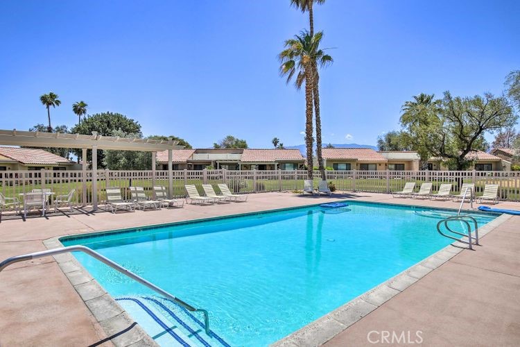 77313 Preston Trail Palm Desert, CA 92211 - Photo 12 of 15 a view of a swimming pool with a lawn chairs under an umbrella