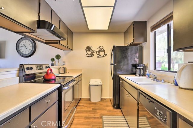 77313 Preston Trail Palm Desert, CA 92211 - Photo 6 of 15 a kitchen with a stove a sink and a refrigerator