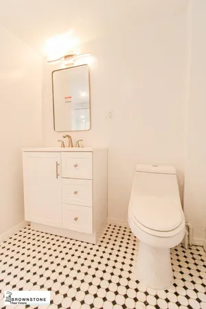 a bathroom with a sink a toilet a mirror and vanity