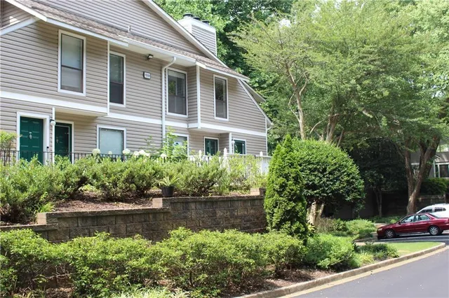 a front view of a house with a yard and potted plants
