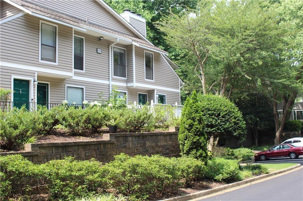 a front view of a house with a yard and potted plants