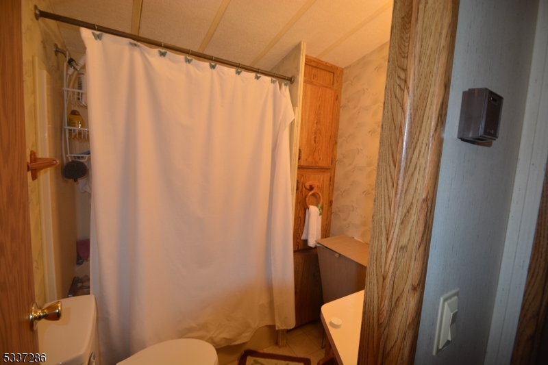 42 Elm Village Vernon, NJ 07461 - Photo 18 of 33 a bathroom with a shower curtain
