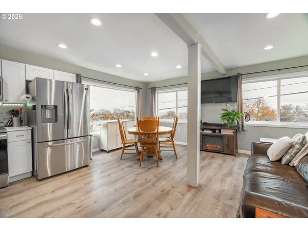 a kitchen with stainless steel appliances wooden floor and dining table