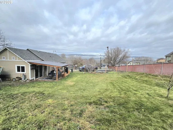 a view of a house with a big yard and large trees