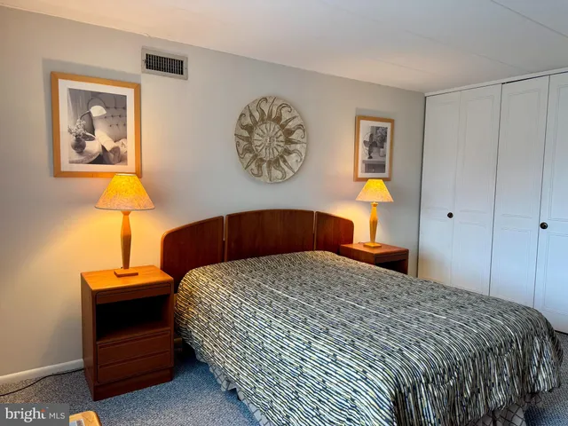 a bedroom with a bed and painting on the wall