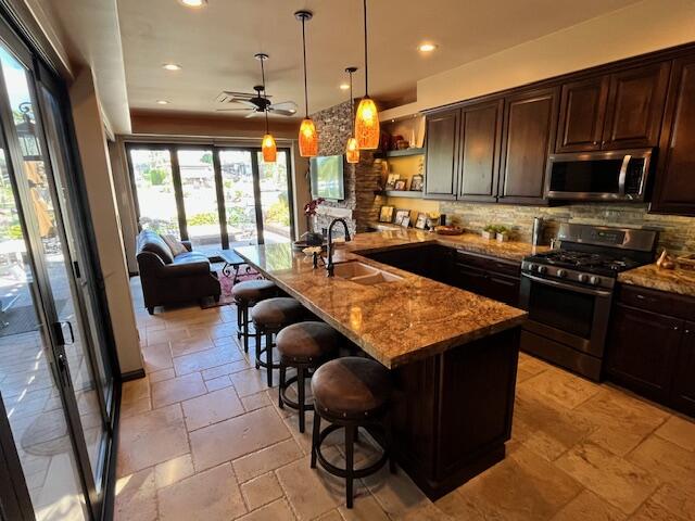 80501 Ave 48, Unit 214 Indio, CA 92201 - Photo 4 of 21 a kitchen with stainless steel appliances granite countertop a stove top oven a sink dishwasher a dining table and chairs with wooden floor