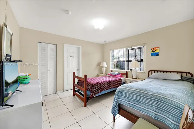 a bedroom with two beds and a large window