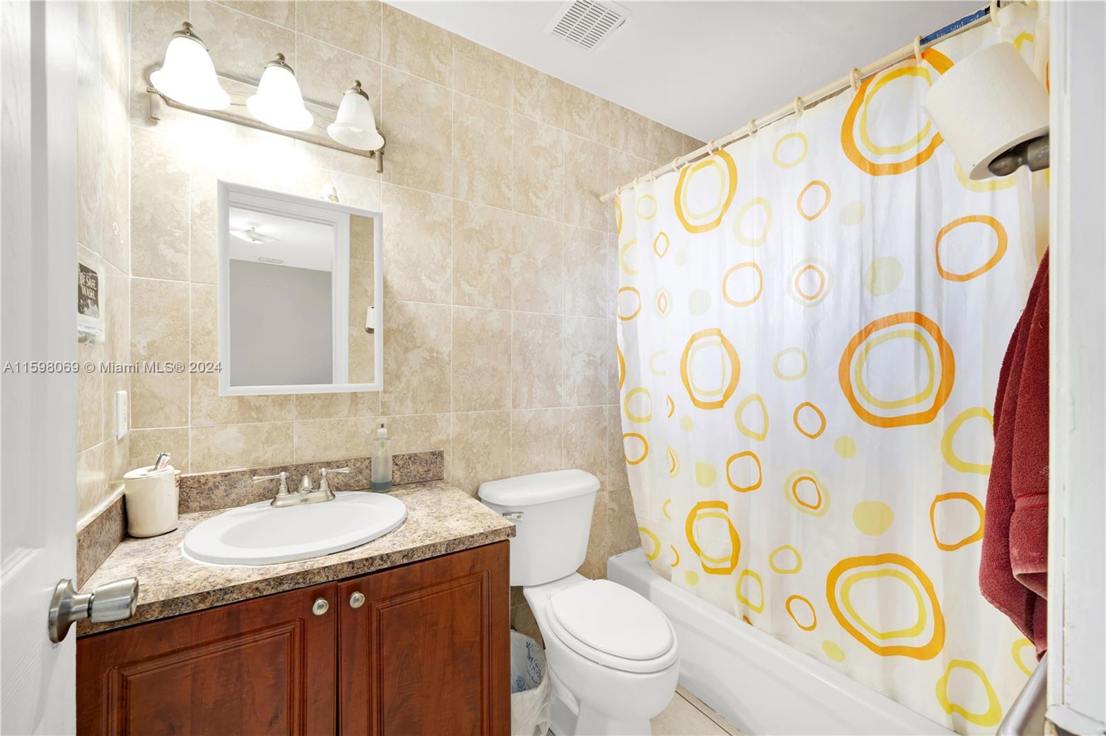 1786 Northwest 47th Terrace Miami, FL 33142 - Photo 18 of 25 a bathroom with a granite countertop toilet sink and a mirror