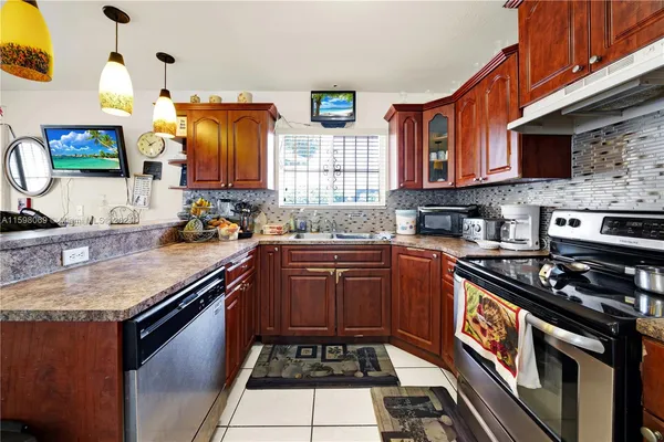 a kitchen with stainless steel appliances granite countertop a stove a sink and a microwave