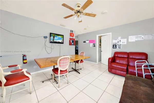 a living room with furniture a rug and a fan