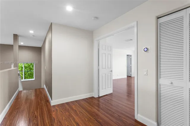 a view of a hallway with wooden floor and stairs