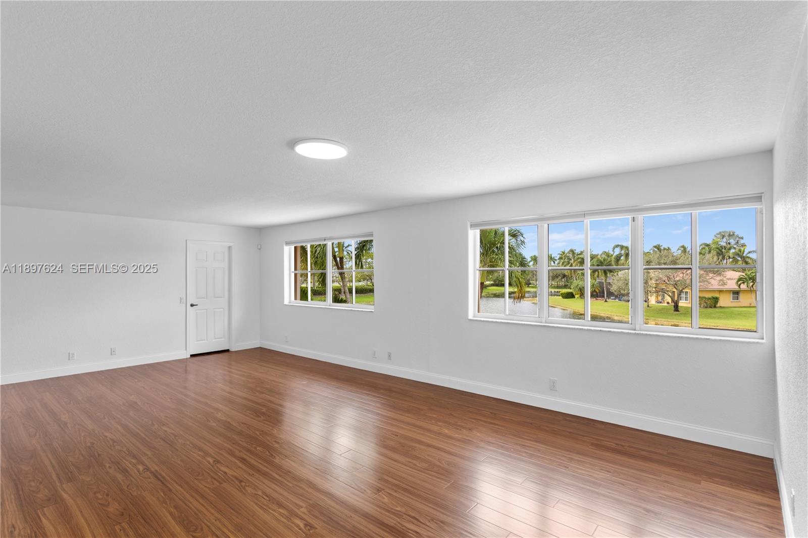 3620 Heron Ridge Lane Weston, FL 33331 - Photo 13 of 37 a view of an empty room with wooden floor and a window