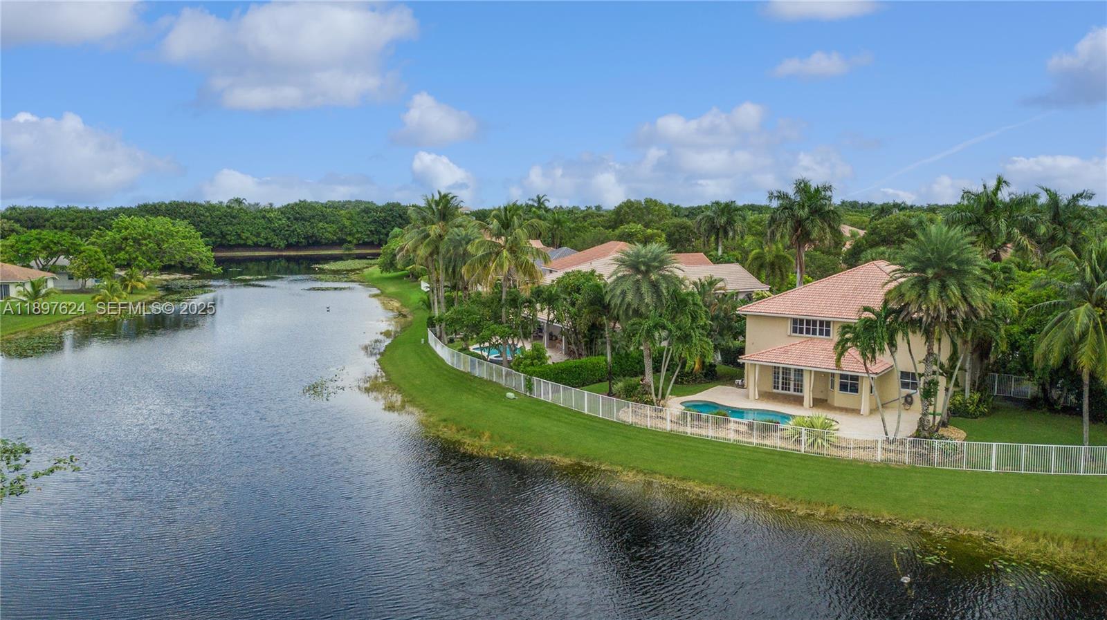 3620 Heron Ridge Lane Weston, FL 33331 - Photo 28 of 37 a view of a lake with houses in the back