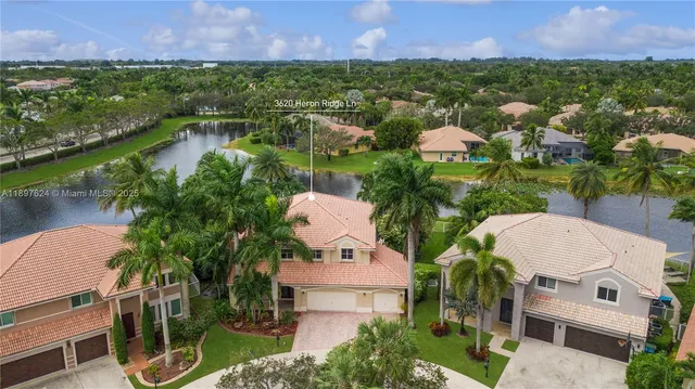 an aerial view of multiple houses with outdoor space and lake view