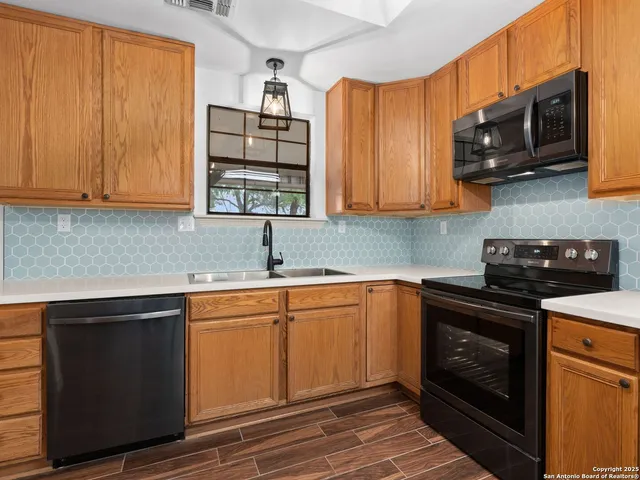 a kitchen with stainless steel appliances granite countertop a sink stove and microwave