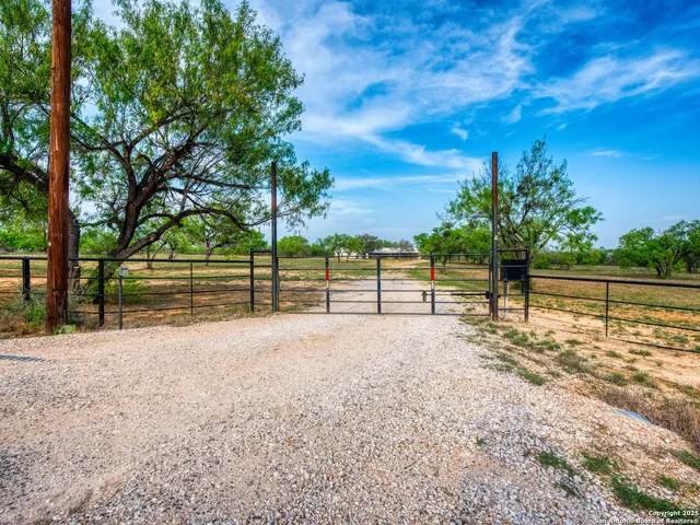 a view of a yard with wooden fence