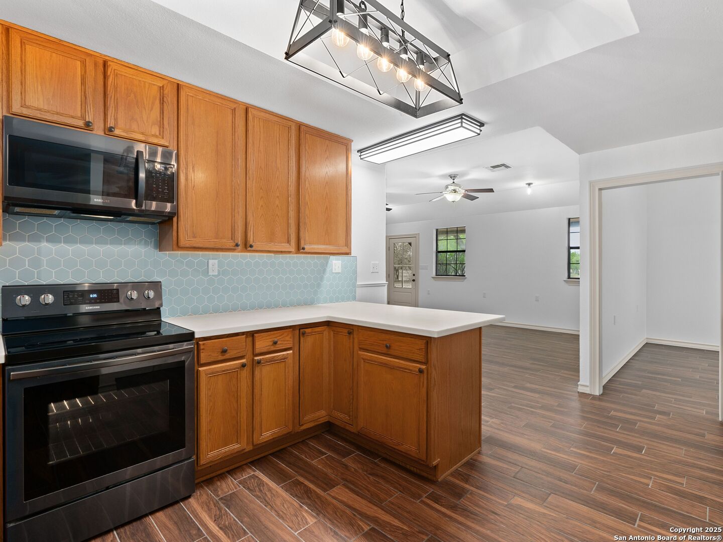 601 Wild Flower Drive Lytle, TX 78052 - Photo 21 of 50 a kitchen with stainless steel appliances granite countertop a stove and a microwave