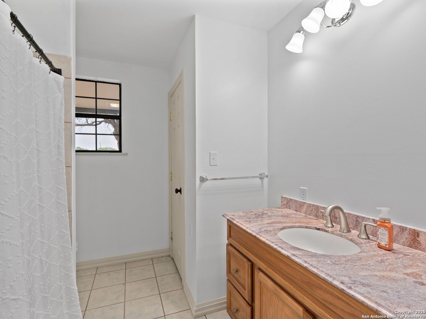 601 Wild Flower Drive Lytle, TX 78052 - Photo 24 of 50 a bathroom with a granite countertop sink a mirror and vanity
