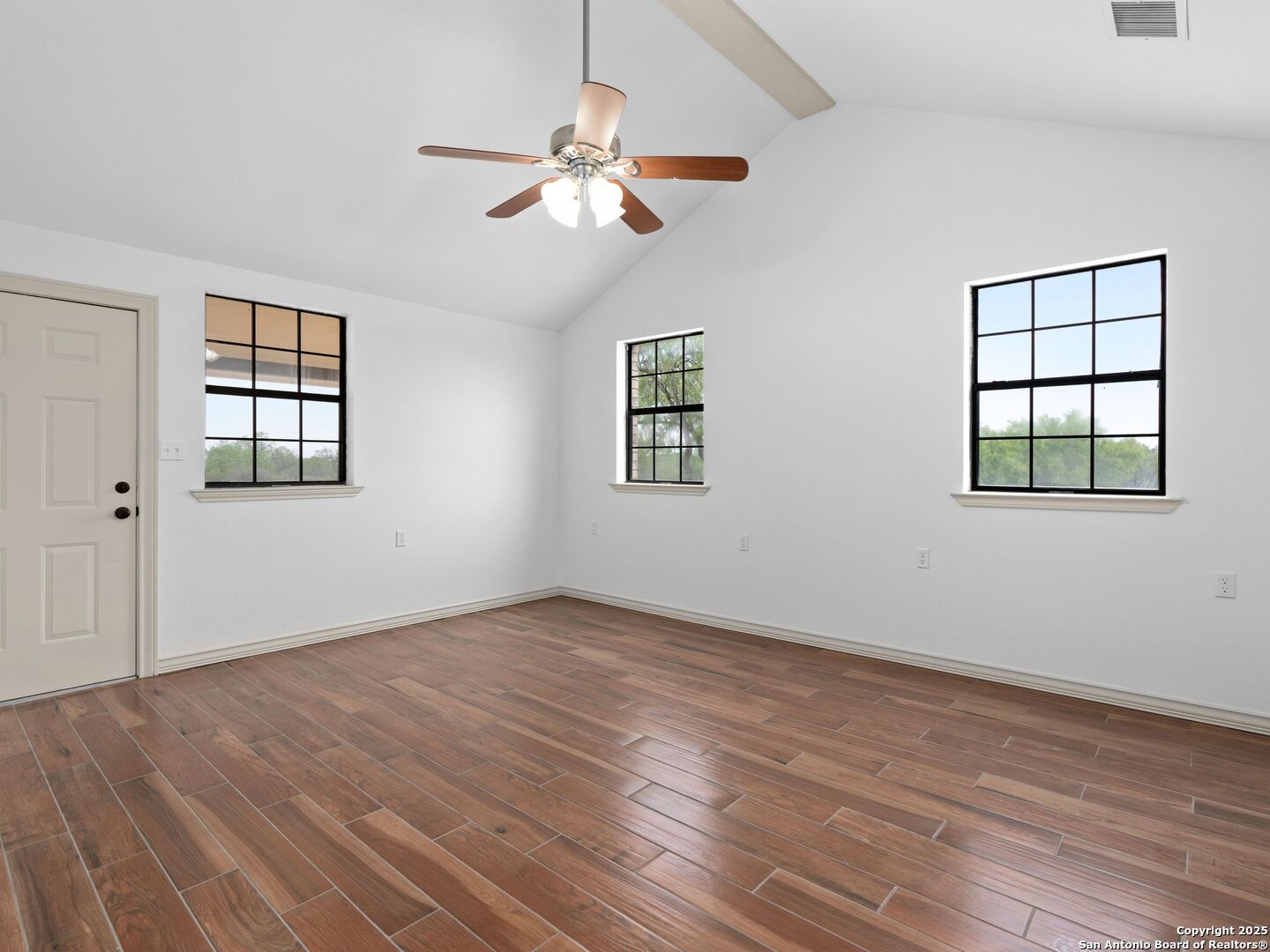 601 Wild Flower Drive Lytle, TX 78052 - Photo 25 of 50 a view of an empty room with wooden floor and a window