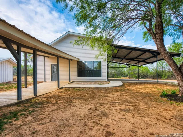 a view of a house with backyard and a porch