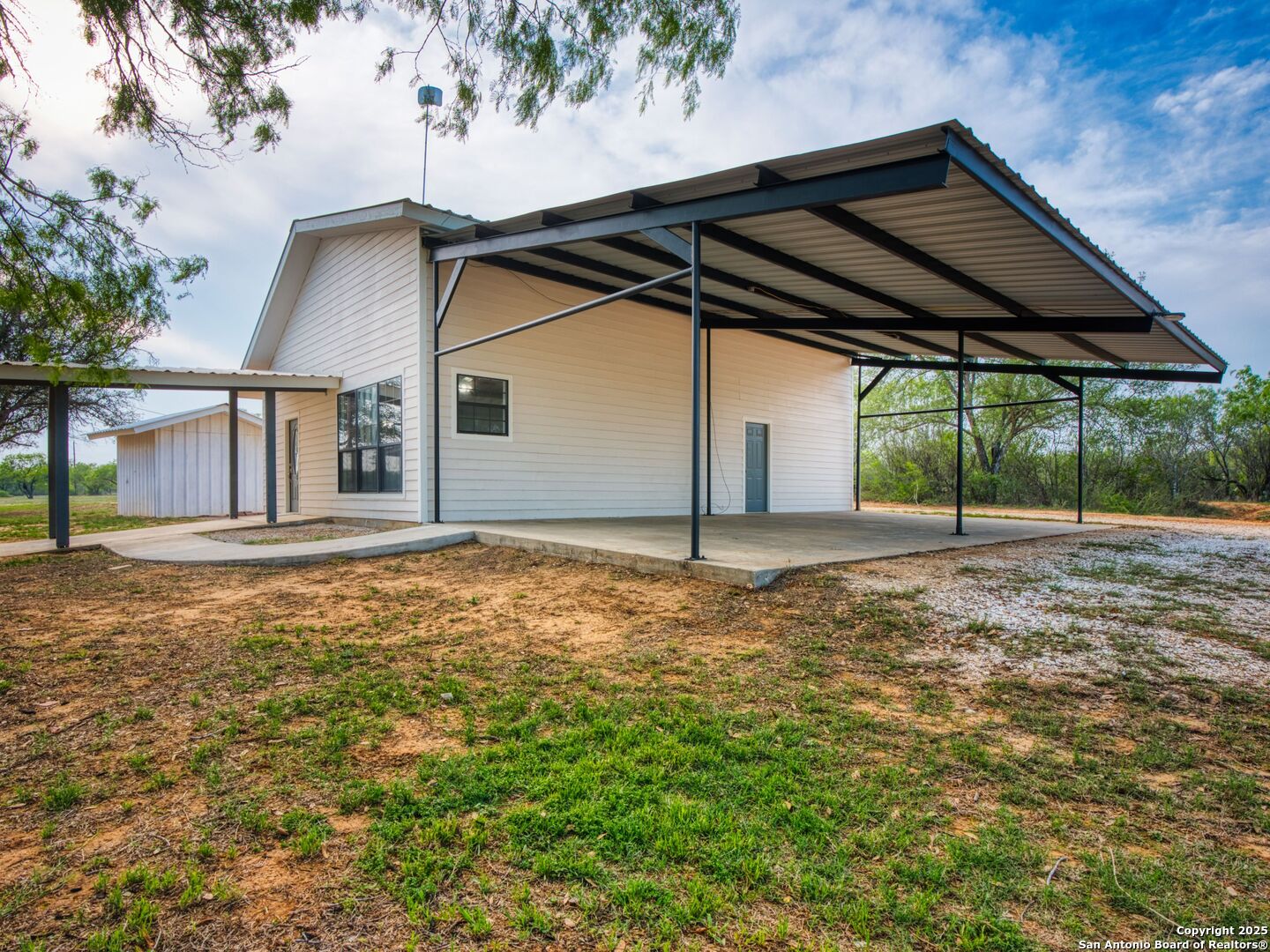 601 Wild Flower Drive Lytle, TX 78052 - Photo 34 of 50 a backyard of a house with table and chairs under an umbrella