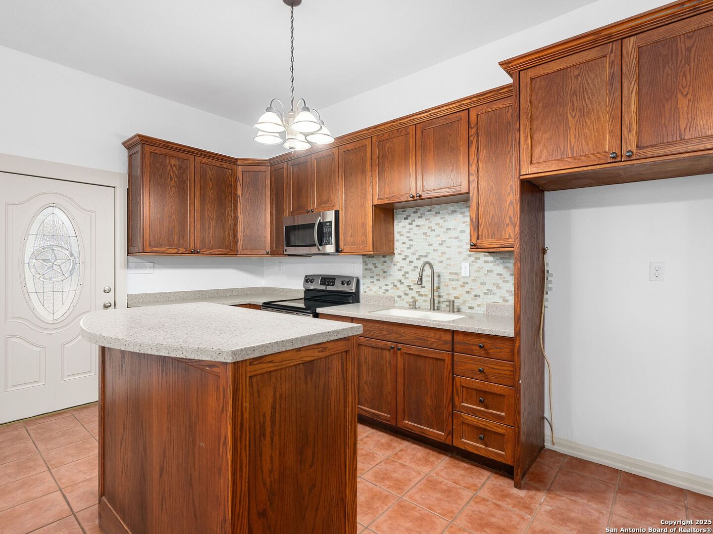 601 Wild Flower Drive Lytle, TX 78052 - Photo 38 of 50 a kitchen with stainless steel appliances granite countertop a refrigerator a sink dishwasher a stove with wooden cabinets and floor