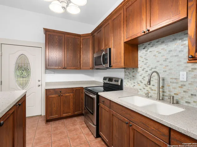 a kitchen with stainless steel appliances granite countertop a sink a stove and cabinets