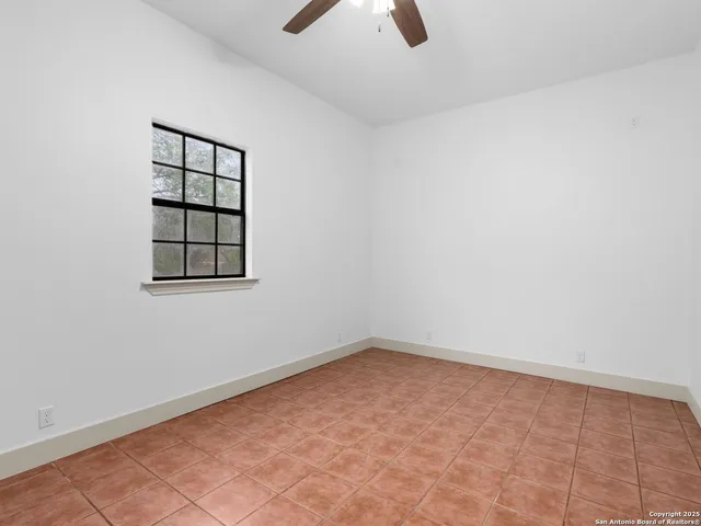 an empty room with chandelier fan