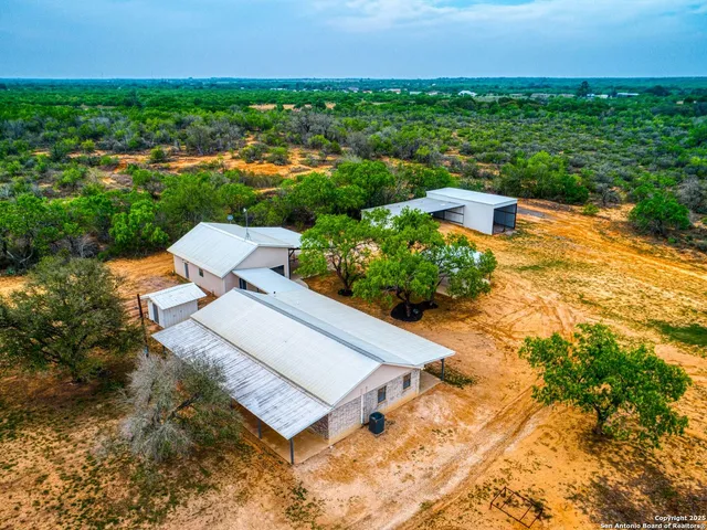 an aerial view of a house with a garden and lake view