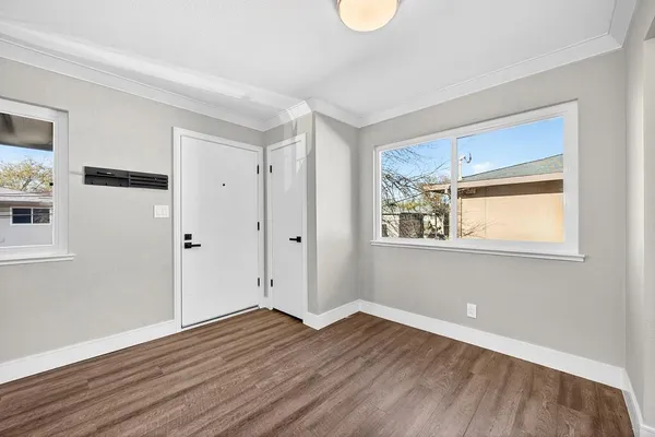 a view of a room with wooden floor and white walls