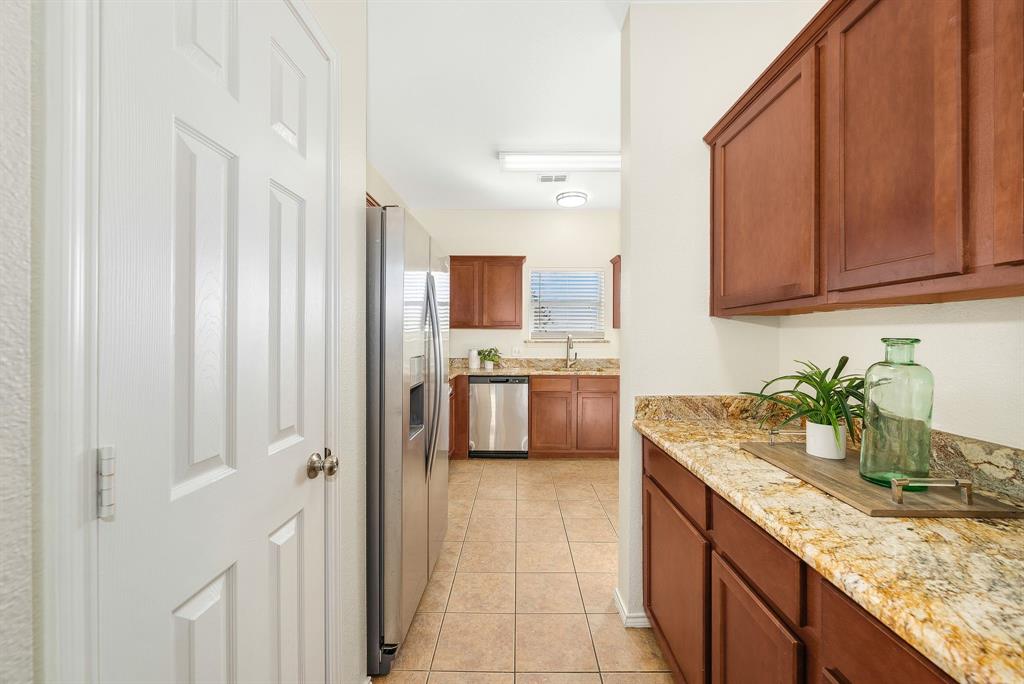2400 Rushing Springs Drive Fort Worth, TX 76118 - Photo 16 of 40 a kitchen with granite countertop a sink stainless steel appliances a counter top space and cabinets