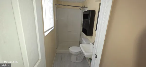 a bathroom with a granite countertop toilet and a shower