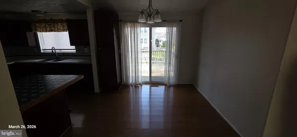 a view of hallway with wooden floor and chandelier