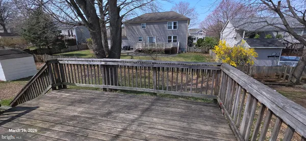 a view of street with wooden fence and trees