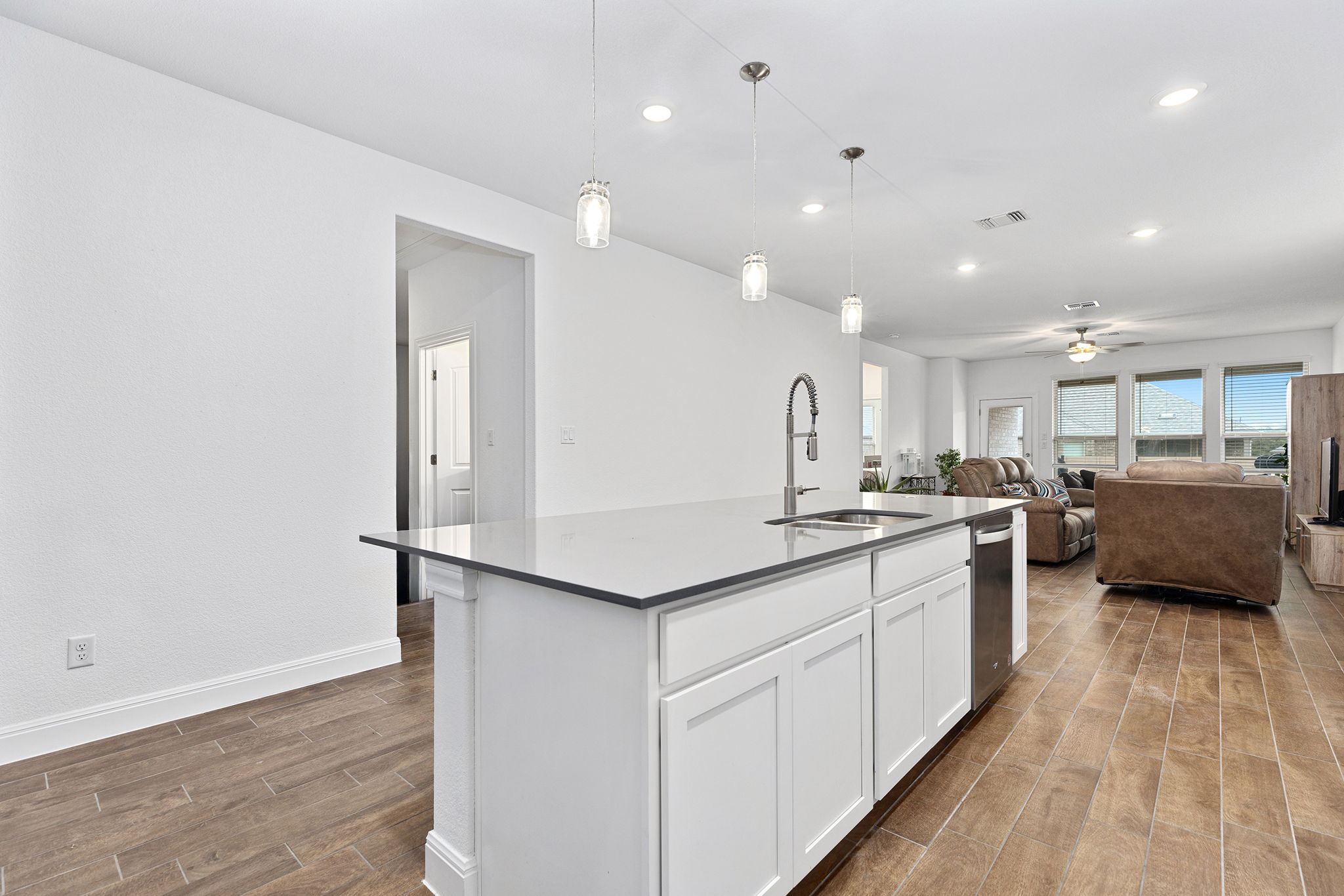 116 Raleigh Drive Georgetown, TX 78633 - Photo 7 of 28 A streamlined kitchen island with a sleek countertop and contemporary lighting creates an inviting open-concept living space.