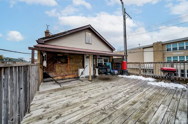 a view of a house with wooden deck and furniture